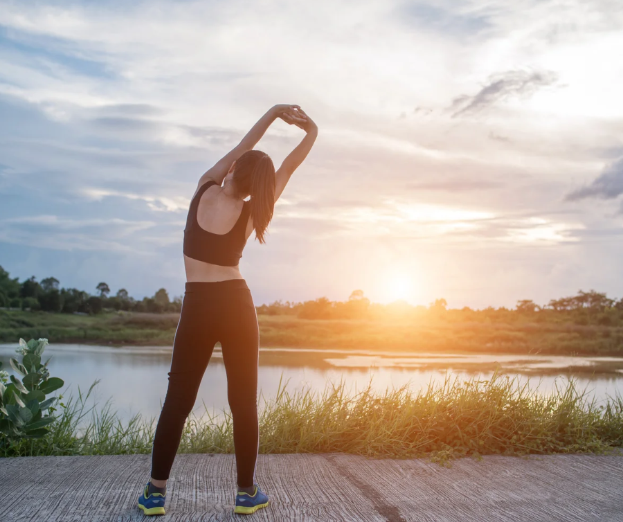 a woman stretching at sunrise